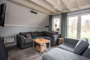 sala de estar con sofá y mesa en Stijlvolle vakantiewoning just for holliday, en Gramsbergen