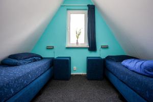 2 camas individuales en una habitación con ventana en Stijlvolle vakantiewoning just for holliday, en Gramsbergen