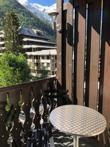 un tavolo su un balcone con tavolo e bicchieri da vino di Chamonix Centre a Chamonix-Mont-Blanc
