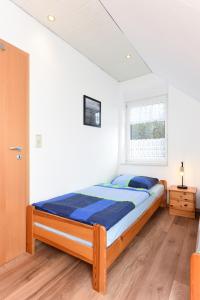 1 dormitorio con 1 cama en una habitación blanca en Ferienwohnung Wattgeflüster, en Esens