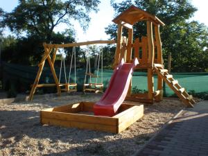 a playground with a slide and a swing set at Penzión ONE in Dolný Ohaj