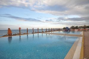 a swimming pool with the ocean in the background at Aylimas Family Hotel in Monastir