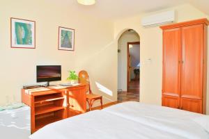 a bedroom with a bed and a desk with a computer at Nyerges Vendégfogadó in Hegykő