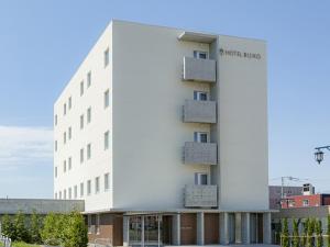 a white building with a sign on the side of it at Hotel Bijiko in Bibai