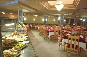 a restaurant with tables and chairs with food on them at Aylimas Family Hotel in Monastir