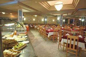 a restaurant with tables and chairs with food on them at Chiraz Club - Families Only in Monastir