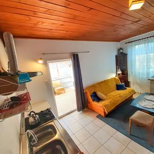 ein Wohnzimmer mit einem gelben Sofa in einem Zimmer in der Unterkunft Apartamenty - Mazurski Zaścianek - Kruklanki in Kruklanki