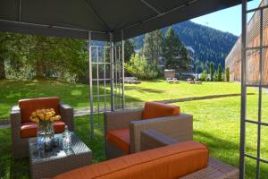 a screened in porch with two chairs and a table at Kongress Hotel Davos in Davos