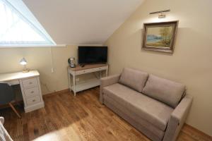 ein Wohnzimmer mit einem Sofa und einem TV in der Unterkunft Hotel Jonapolis in Jonava