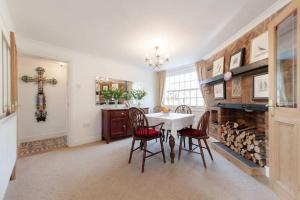 a dining room with a table and chairs and a fireplace at Swan Guest House LONDON - HEATHROW in Hillingdon