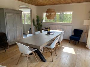 une salle à manger avec une grande table et des chaises en bois dans l'établissement Family bungalow with garden for 6-8 people, à Cadzand