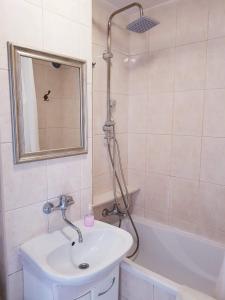 a bathroom with a sink and a tub and a mirror at Warsaw Center - Apartment near Central Railway Station in Warsaw