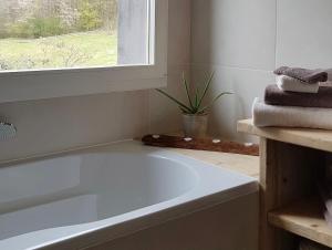 龙尚CŒUR VERT ökologisch mit viel Ambiente für Seelen-Wellness的带窗户的浴室内的白色浴缸 更多29张照片