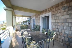 un patio avec une table et des chaises sur un balcon dans l'établissement BMV apartment 1 with sea view, à Sveti Stefan