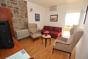 un salon avec un canapé et deux chaises dans l'établissement BMV apartment 1 with sea view, à Sveti Stefan