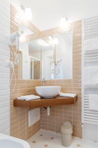 a bathroom with a sink and a mirror at Hotel Aganoor in Castiglione del Lago