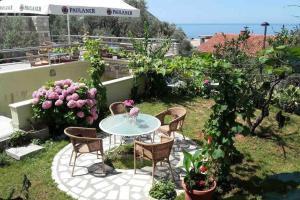 eine Terrasse mit einem Tisch, Stühlen und Blumen in der Unterkunft BMV apartment 2 with big terrace in Sveti Stefan