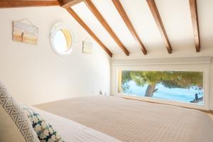 ein Schlafzimmer mit einem Bett und einem großen Fenster in der Unterkunft Villa Renata & Villa Filippos with private Plunge Pool by Konnect in Agios Gordios