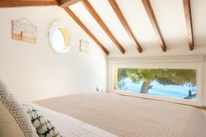 a bedroom with a bed and a large window at Villa Renata & Villa Filippos with private Plunge Pool by Konnect in Agios Gordios
