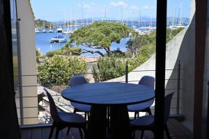 a table and chairs on a balcony with a view of the water at L'Arche de Porquerolles in Porquerolles