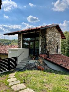 una pequeña casa de piedra con porche y escaleras en Locanda Vecchio Cipresso, en Chiaverano