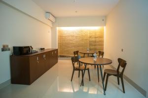 a kitchen and dining room with a table and chairs at Jatra Flagship Sylhet City Centre in Sylhet