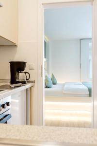 eine Küche mit einem Schlafzimmer mit einem Bett und einem Fenster in der Unterkunft bedpark Stellingen in Hamburg