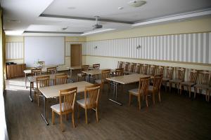 a classroom with wooden tables and chairs and a whiteboard at Restoranas - Svečių Namai - Restaurant - Guest House Perkūnkiemis in Elektrėnai