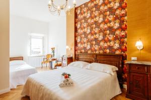 a bedroom with a bed with a painting on the wall at Hotel Aganoor in Castiglione del Lago