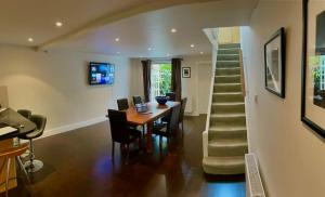 uma sala de jantar com uma mesa e uma escada em Luxury Central London 3 Bedroom Family House em Londres