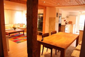 阿爾特施泰騰的住宿－菲林沃格魯恩酒店，厨房以及带木桌和椅子的客厅。