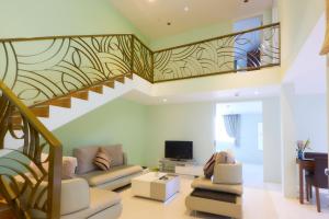 a living room with a staircase with a couch and a tv at Season Residence in Phnom Penh