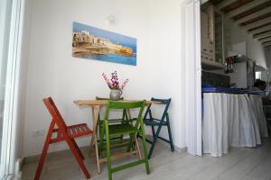 トラーパニにあるLe Casuzze di Trapani Vista Mareの壁画付きのキッチン(テーブル、椅子付)