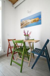 トラーパニにあるLe Casuzze di Trapani Vista Mareの壁画のある部屋内のテーブルと椅子