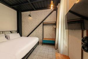 イスタンブールにあるRaven Suites Taksimの白いベッドとレンガの壁が備わるベッドルーム1室が備わります。