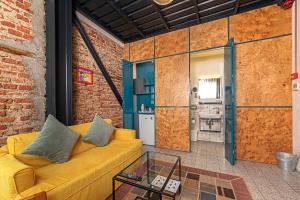 a living room with a yellow couch and a brick wall at Raven Suites Taksim in Istanbul