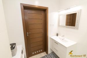 Un baño con puerta de madera y lavabo. en APARTAMENT 48 HEL, en Hel 30 fotos más