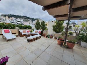 a patio with a couch and chairs on a balcony at Amazing Views 1 in Athens