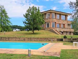 una casa con piscina frente a ella en Villa Ulivo, en Grotte di Castro