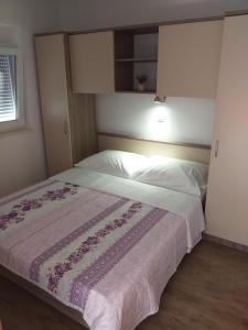 a bedroom with a large bed with white sheets at Apartmani Petra in Olib