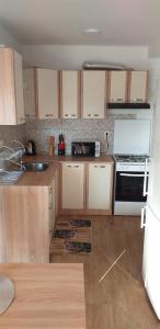 a kitchen with wooden cabinets and a stove top oven at Apartmani Petra in Olib