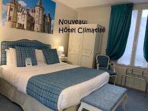 a hotel room with a bed, desk, and bedspread at Kyriad Saumur Centre in Saumur