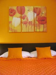a bed with two orange pillows in a bedroom at B&B Domu Mea in Sarroch
