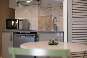 a kitchen with a table and a microwave at L'Arche de Porquerolles in Porquerolles