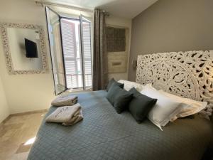 a bedroom with a large bed with pillows and a mirror at L'Arche de Porquerolles in Porquerolles