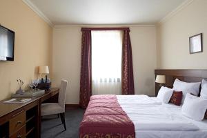 um quarto de hotel com uma cama, uma secretária e uma janela em Oroszlános Borhotel em Tállya