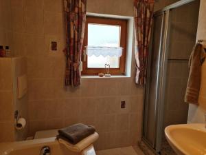Un baño con bañera, inodoro y ventana. en Ferienhaus am Bach, en Riedenburg 15 fotos más