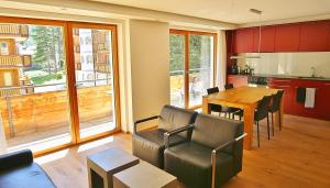 - une cuisine et une salle à manger avec une table et des chaises dans l'établissement Elite Alpine Lodge - Apart & Breakfast, à Saas-Fee