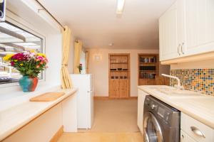 een keuken met een wasmachine en droger en een raam bij Aftonbank in Pitlochry