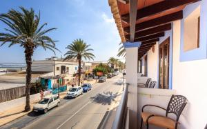 a balcony with a view of a street and palm trees at Hostal la Savina in La Savina